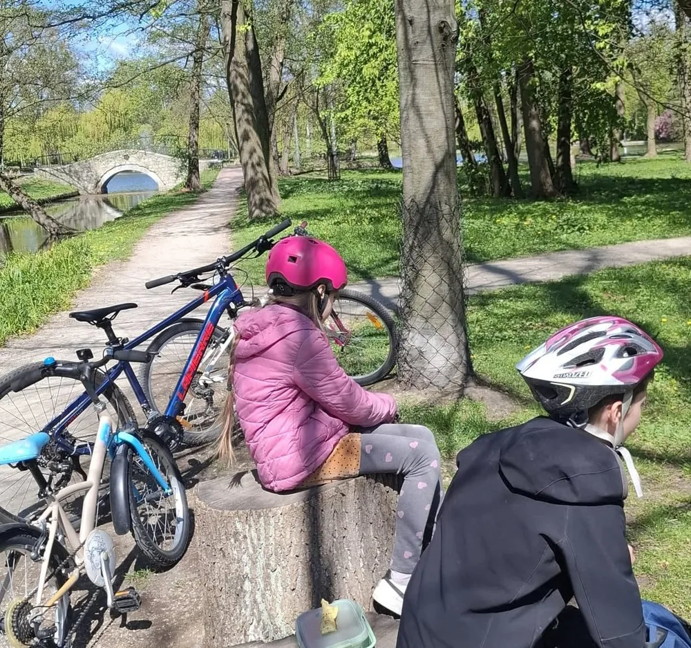 Dzieci odpoczywające w parku nad rzeką wiosną
